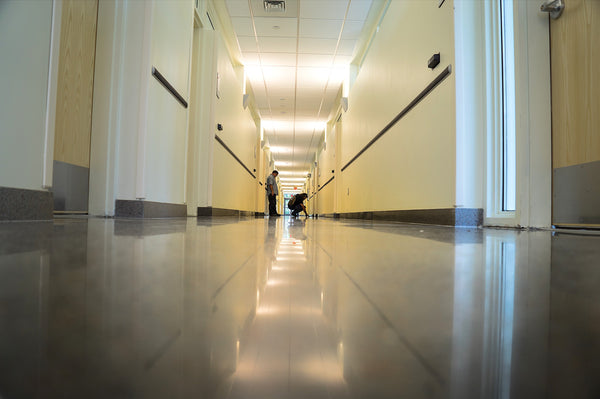 A polished concrete floor with two men standing in the distance.