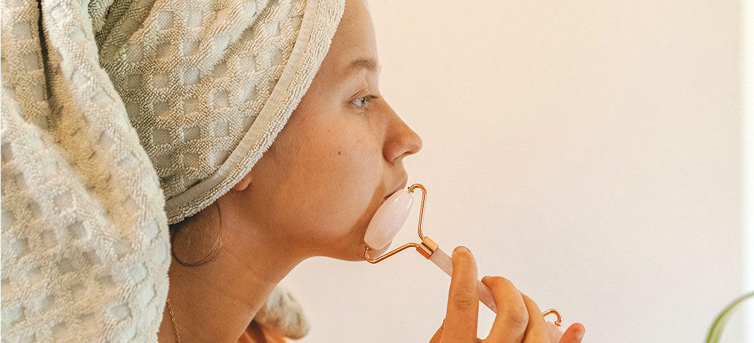 A serene image depicting a woman indulging in a skincare ritual, skillfully using a face massager to rejuvenate and stimulate her skin, reflecting a commitment to beauty and wellness.