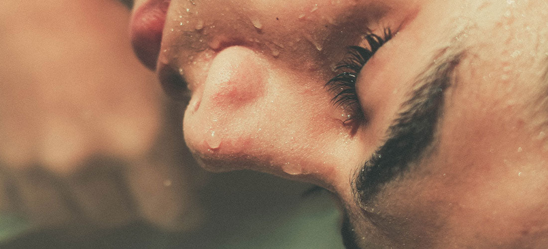 A close-up image showcasing a woman's face with water droplets delicately resting on her nose, highlighting the purity, freshness, and hydrating essence of her skincare regimen.