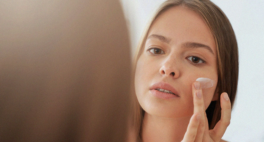 Woman applying Blithe facial cream, showcasing the use of luxury skincare products for a nourishing beauty routine.
