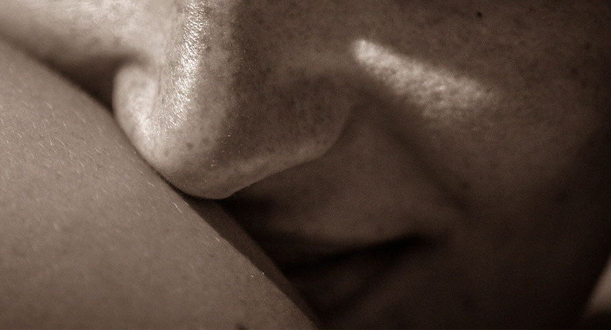 A close-up image focusing on a woman's nose and arm, highlighting the texture and details of her skin.