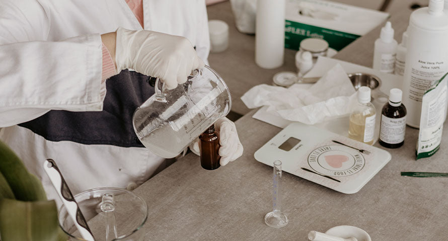Lab scientist meticulously pouring a liquid into a bottle, symbolizing the precision and care in the formulation of high-quality skincare products.