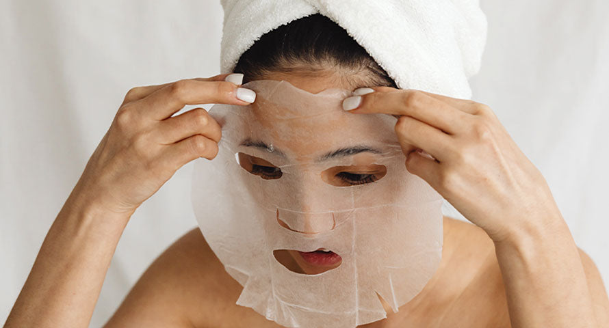 Woman applying a face mask, capturing a moment of self-care and skin nourishment.