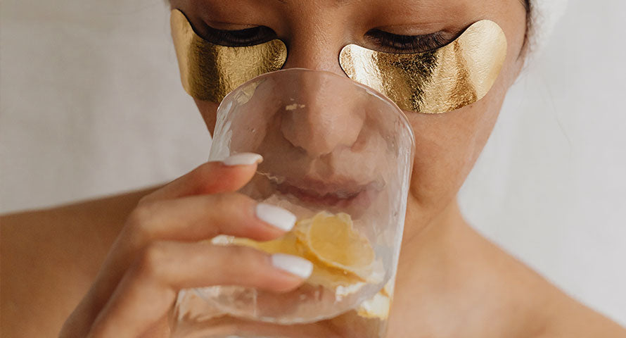 An image capturing a woman with eye gel patches carefully placed under her eyes, depicting a moment of pampering and targeted skincare to rejuvenate and refresh the delicate under-eye area.