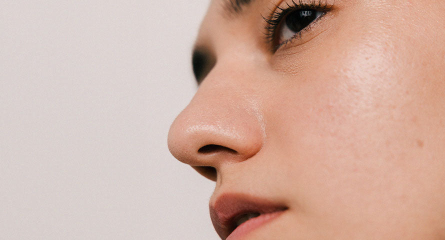 Close-up of a woman's face, showcasing her clear, glowing complexion, exemplifying the benefits of a well-maintained and healthy skin barrier.