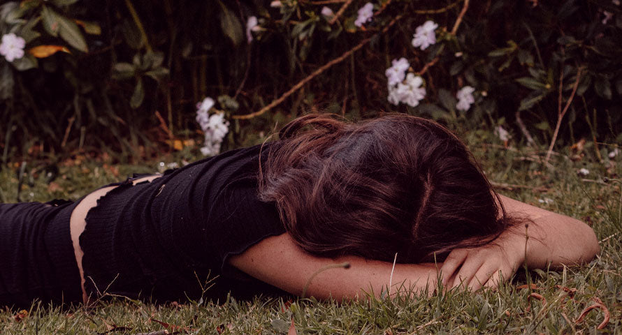 A woman peacefully napping on the grass, enjoying a moment of relaxation and rejuvenation in nature.