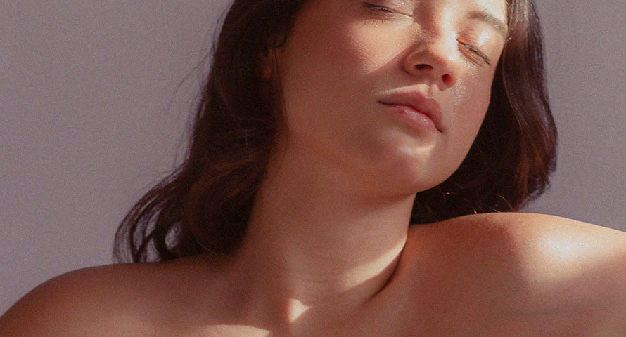 A woman basking in sunlight, illuminating her skin with a radiant glow, symbolizing the beauty and radiance achieved through skincare practices.