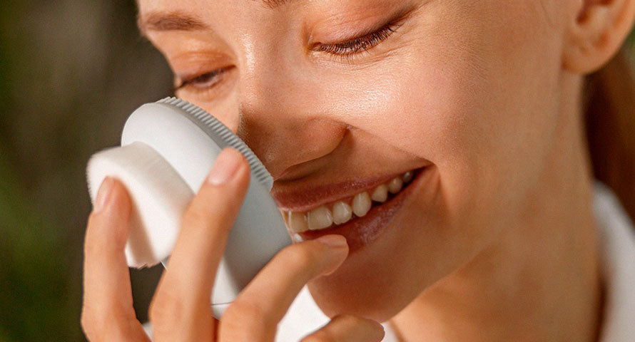Woman using a face massager on her skin, demonstrating a self-care routine aimed at enhancing facial circulation and skin elasticity.