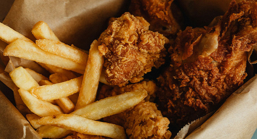 Assortment of unhealthy foods including processed snacks, sugary treats, and fast food items, representing poor dietary choices.