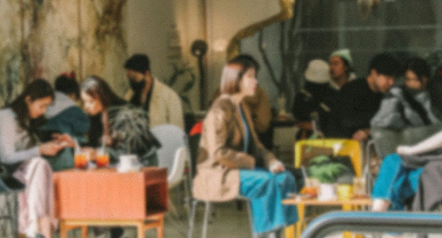 Blurred image of people socializing in a cafe, capturing the lively and bustling atmosphere