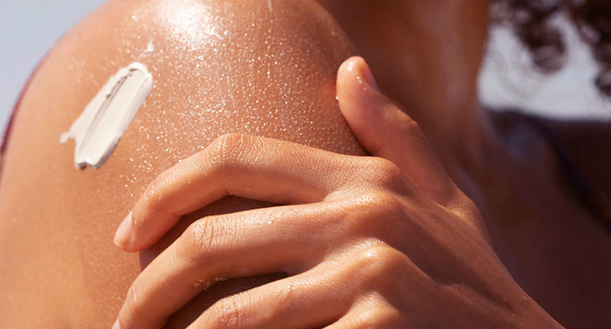 Close-up image of a woman's forearm with a dollop of cream on her skin, showcasing the texture and consistency of the skincare product.