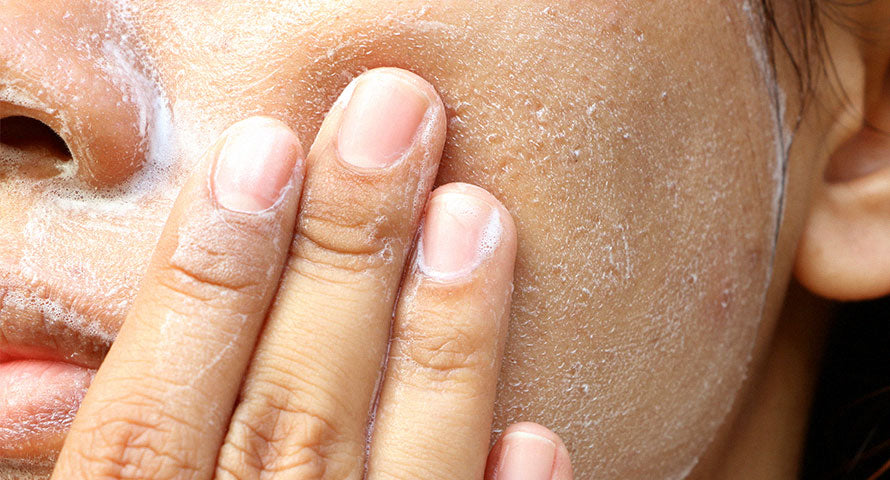 Close-up view of a woman's skin while she washes her face, showcasing the refreshing action and the skincare routine.