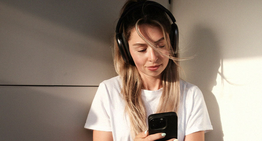 Woman intently looking at her smartphone, highlighting the common habit that necessitates maintaining clean devices for clear skin.