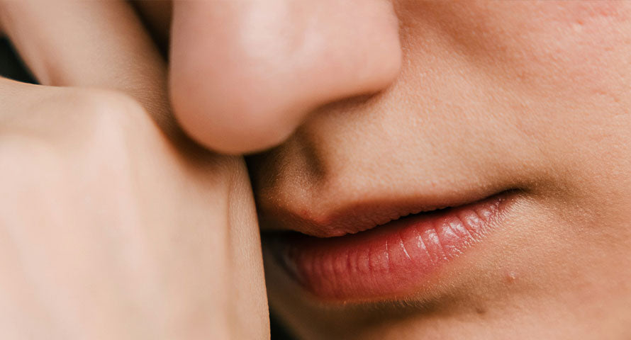 Close-up image of a woman's face, highlighting her complexion with a focus on natural skin texture and signs of aging