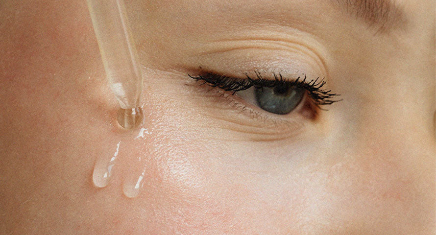 Image of a woman delicately applying serum to her face, showcasing a moment of self-care and skincare routine