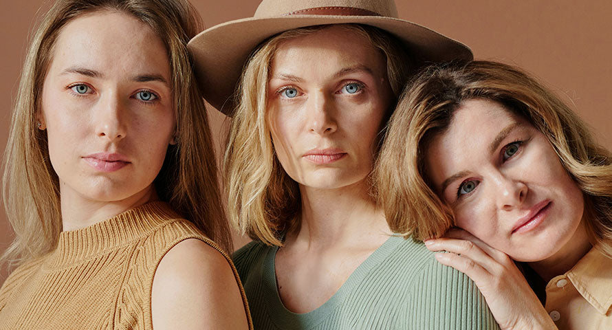 Three diverse women standing together, each radiating confidence and beauty, highlighting the unity and diversity of skincare across different ages.