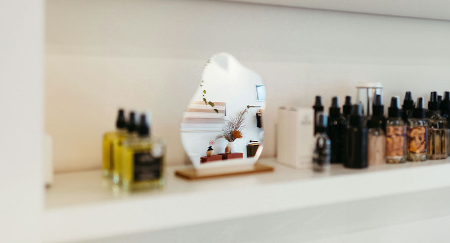 A neatly organized shelf displaying a variety of skincare products, including bottles, jars, and tubes, with clear labels facing forward.