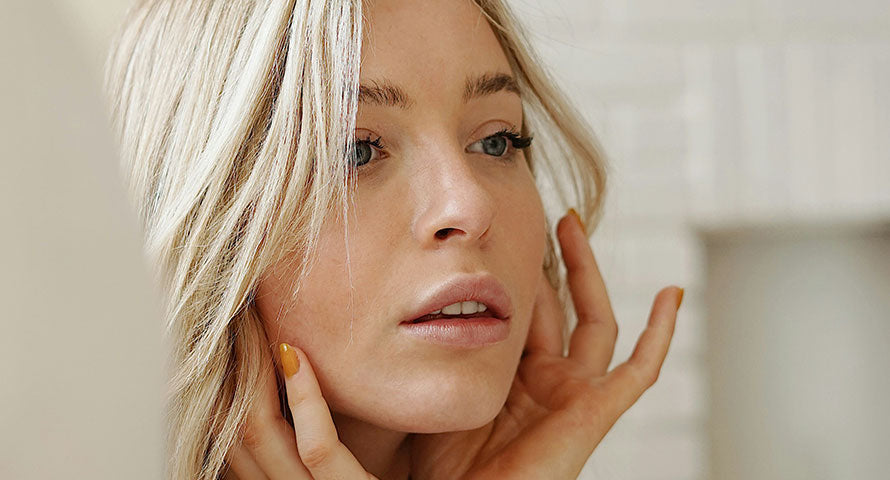  Close-up of a woman looking intently at her reflection, evaluating her skin in a mirror.