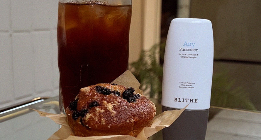 Blithe's Airy Sunscreen positioned next to a refreshing drink and dessert, symbolizing its light, protective qualities suitable for any winter day out.