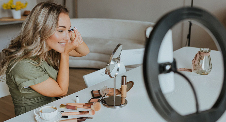 Woman applying mascara, showcasing the Spider Lashes trend, one of the top beauty fads of 2023 on TikTok.