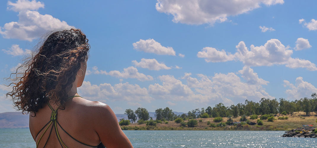 A contemplative image of a woman gazing out at the vast sea, her expression thoughtful and serene, capturing a moment of connection with nature and introspection.