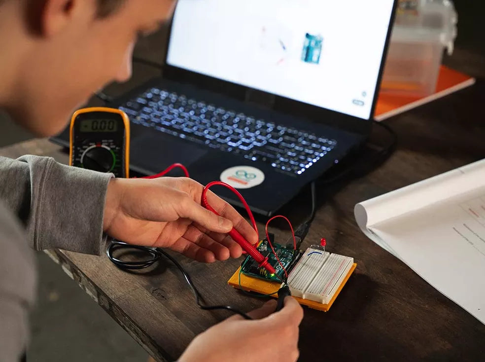 Kid learning electronics with his Arduino Student kit