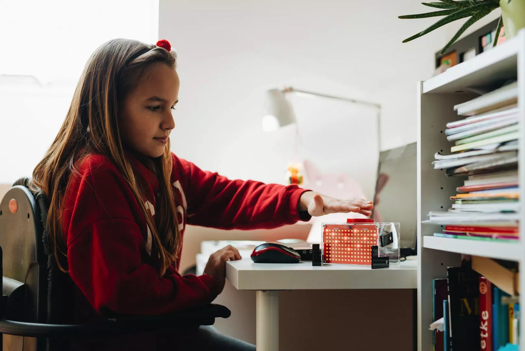 Kid playing with and coding CircuitMess DIY voice assistant - Spencer