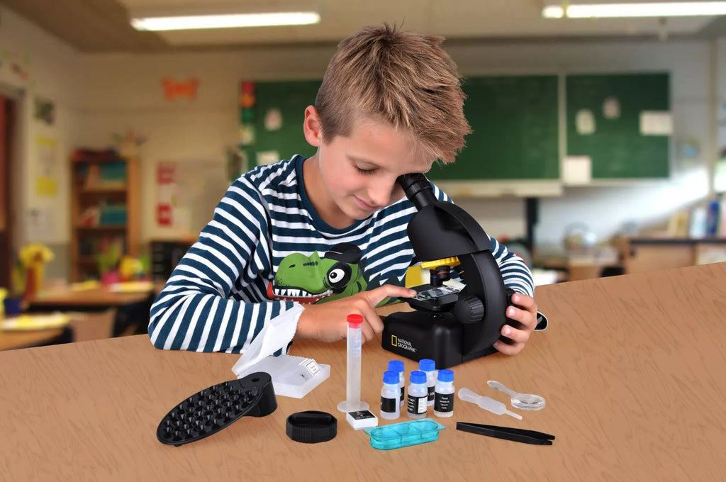 9-year-old boy playing with educational toy - microscope