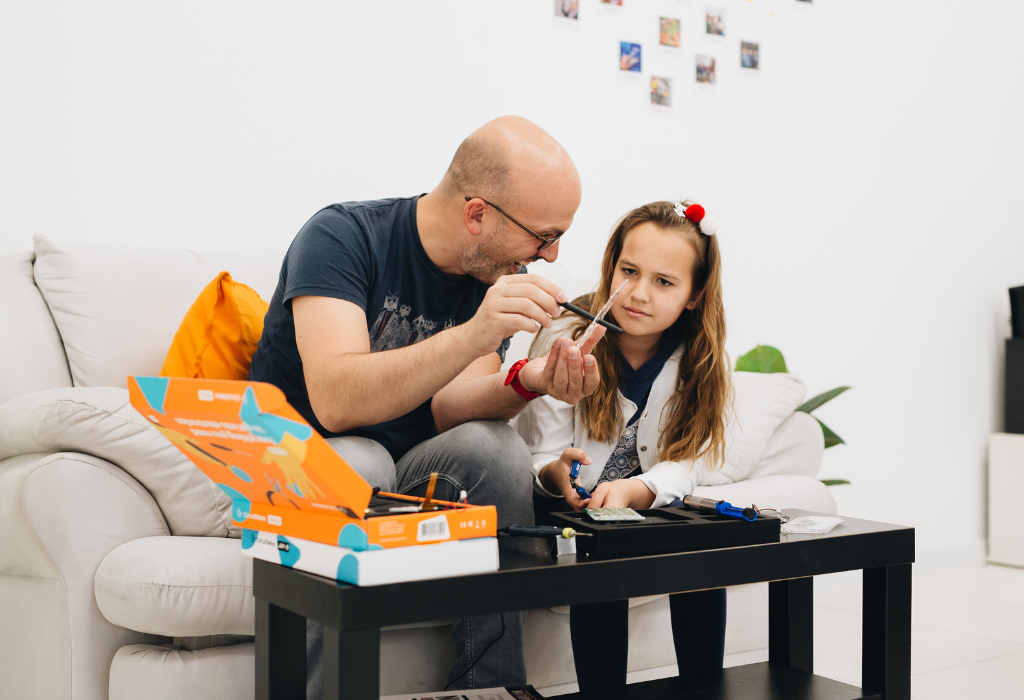 Father and daughter building STEM toys