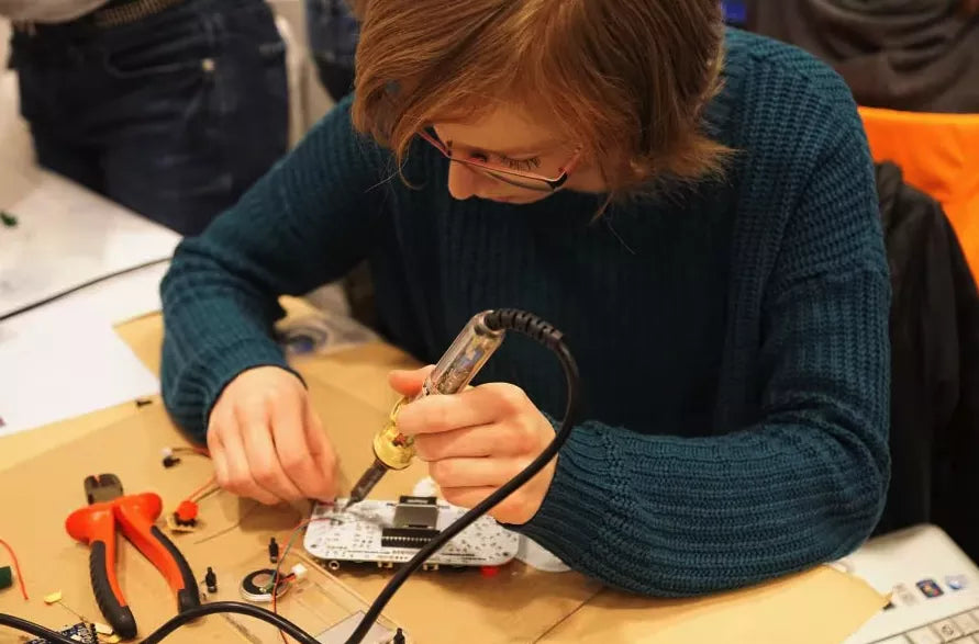 Kid soldering a DIY video game console