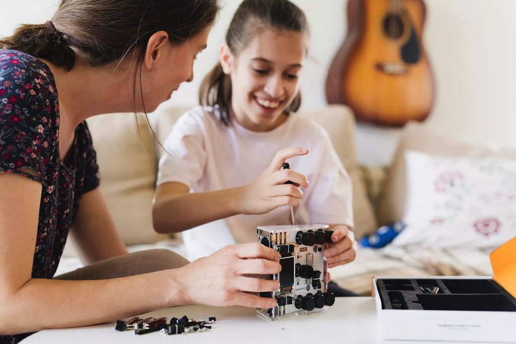 Parent and kid assembling their electronics kit from CircuitMess