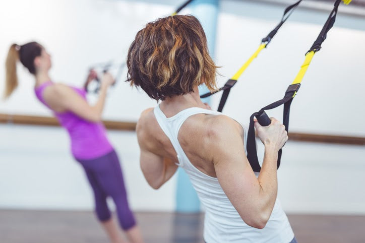 Women Using TRX Straps in Studio