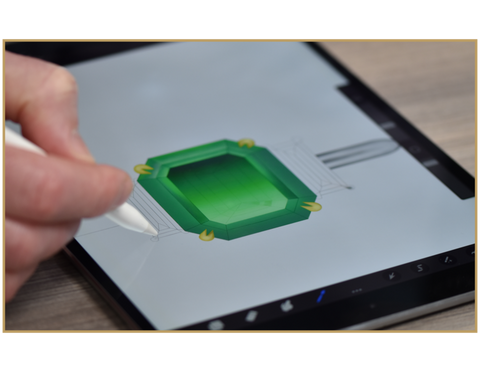 gemmologist designing an emerald engagement ring with shoulders on an iPad 