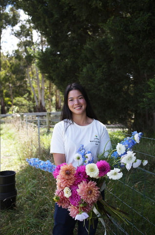 Thanisa holding a mixed bunch of flowers at her farm in Plenty Valley, VIC