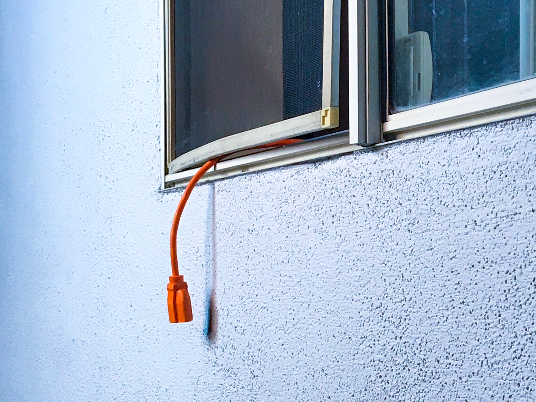 Imagen compuesta que muestra la utilidad ScreenLet: un lado muestra un cable de alimentación desprotegido colgando fuera de una ventana, mientras que el otro lado muestra ScreenLet enrutando de forma segura un cable a través de una pantalla de ventana, protegiendo contra insectos y daños a la pantalla.