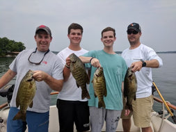 Four men show the small mouth fish caught at the St. Lawrence River.  