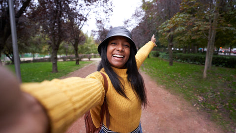 a female traveler taking a selfie with trees around the area