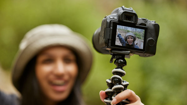 woman filming self using a tripod camera