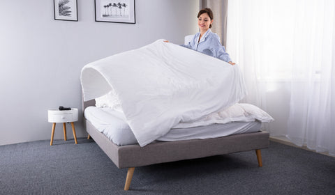 A lady decor her bed with newly laundry white color bamboo bedsheet