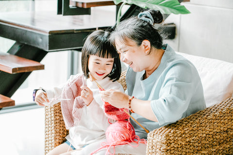 grandmother knitting with granddaughter