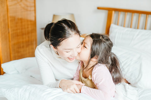 Daughter kissing mom on cheek