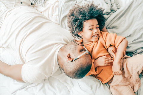 Son and dad cuddling in bed