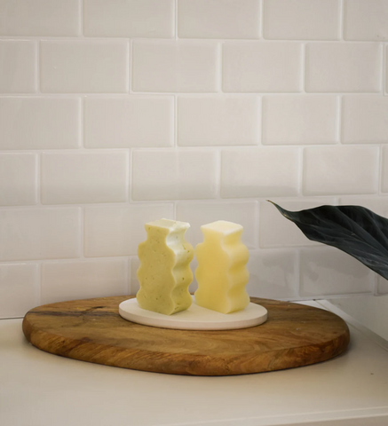 Two Shampoo and conditioner bars photographed on wooden tray
