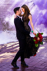 60 second purple Smoke grenade in background behind couple taking engagement pictures