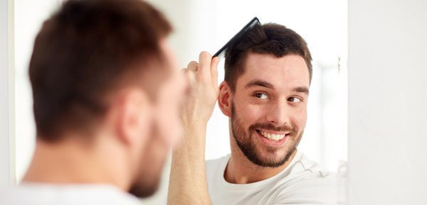 Man grooming hair in mirror