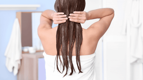 Back view of woman post-shower managing her hair