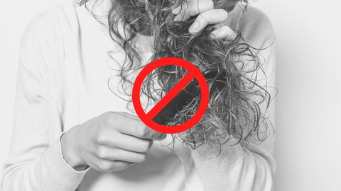 Woman trying to comb dry hair
