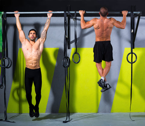 demonstration of how to do a pull up, one man in first position of hanging on the bar, other man in final position, of chin to the bar