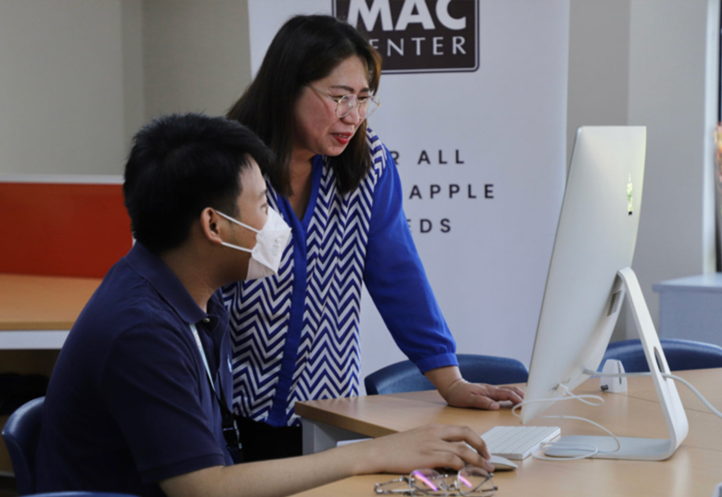 Two people using iMac