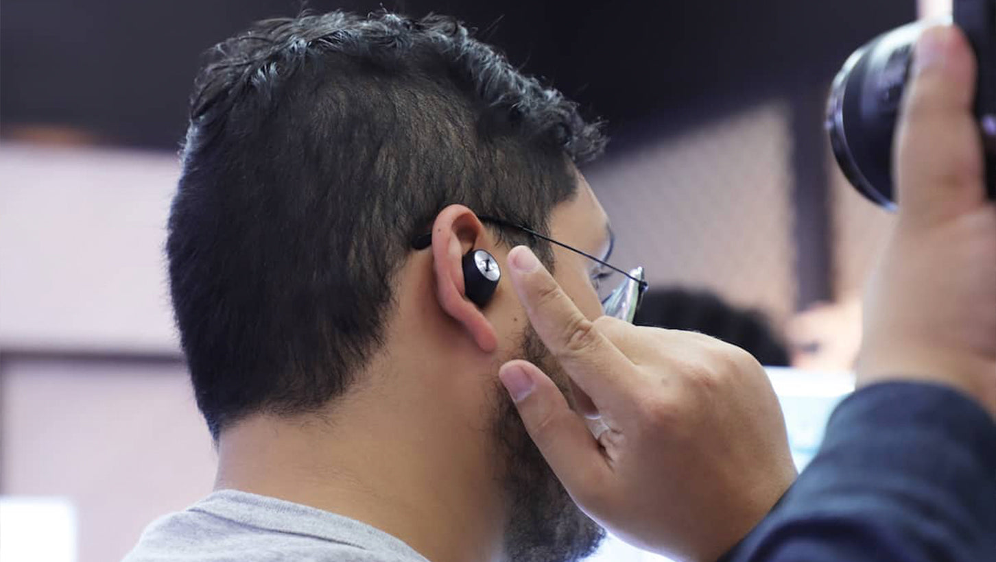 A Man tapping on the Sennheiser MOMENTUM True Wireless Earbuds in his ear